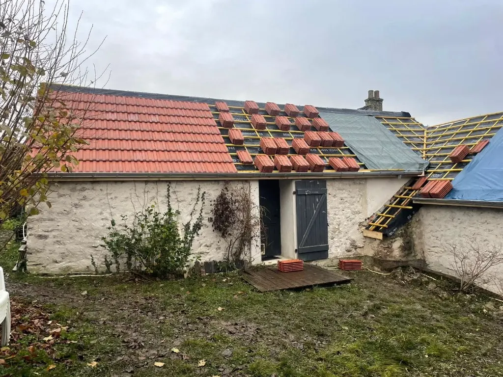 Long bâtiment avec partie couverte en tuiles et partie en travaux